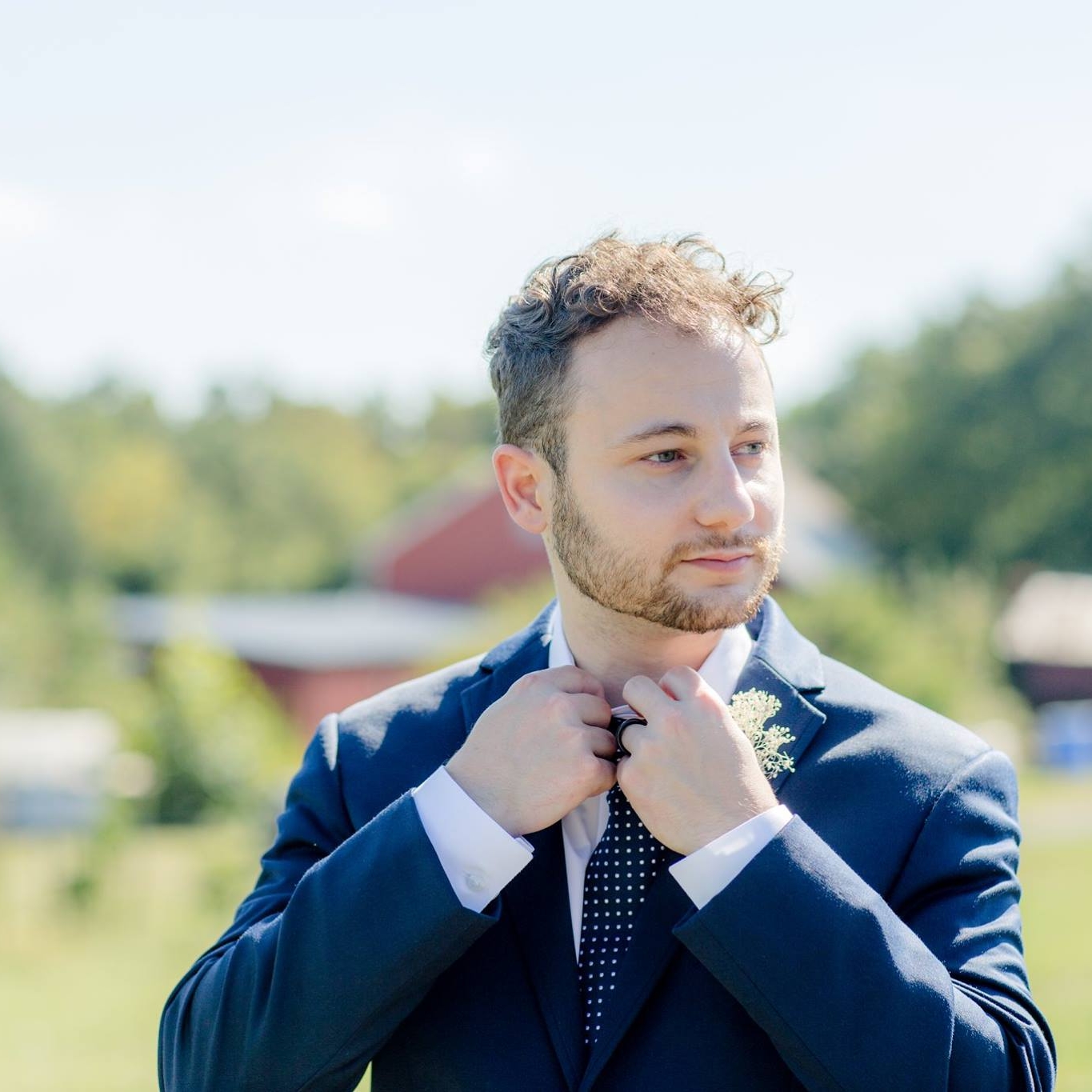 Zac Davis looking off into the distance with a navy blue suit on